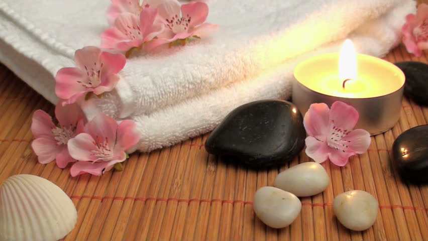 wellness time with candle, stones and blossoms