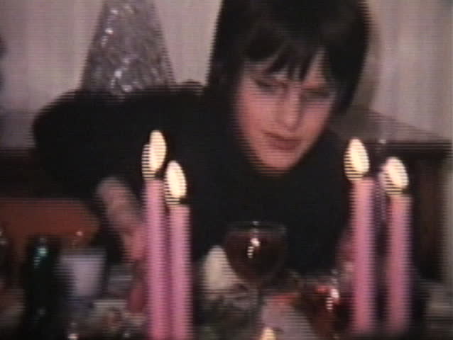 Two brothers making crazy faces at the camera at a family dinner. (1974 - Vintage 8mm film footage)