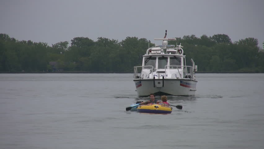 TORONTO, CANADA - JULY 2: Police boat follows inflatable dinghy, Toronto, July 2, 2009. The Toronto Police marine unit is responsible for policing some 460 square miles of open water on Lake Ontario.