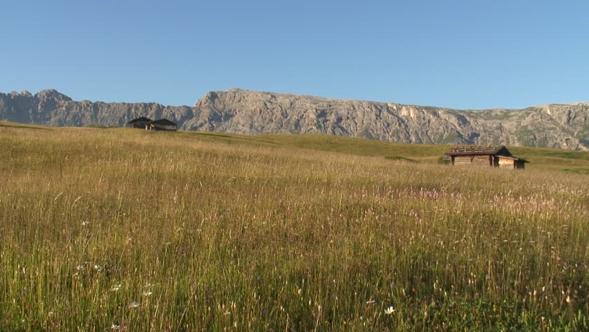 HD 1080i: Hiker in a mountain meadow - Seiser Alm - Southern Tyrol. Sound. Tripod.