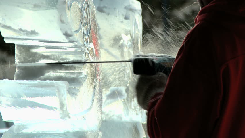 Ice Carving 6- Ice carver using a chain saw on some ice at sunset outdoor display