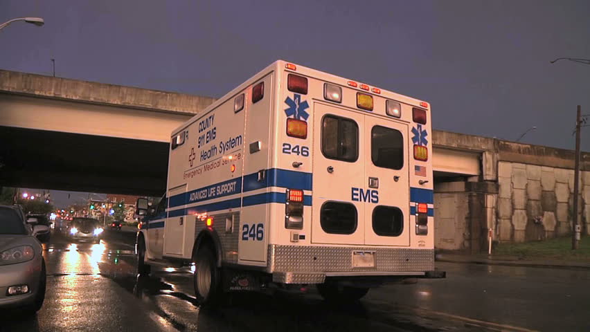 Rear view and flashing lights of a city hospital ambulance.  
