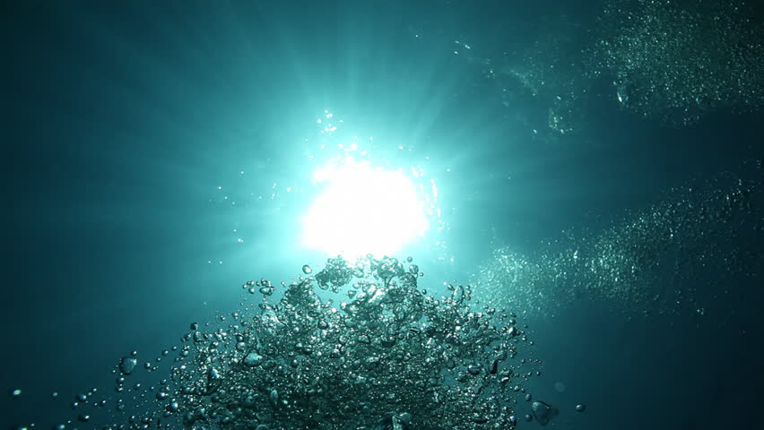 divers view from depth to surface, bubbles and sun