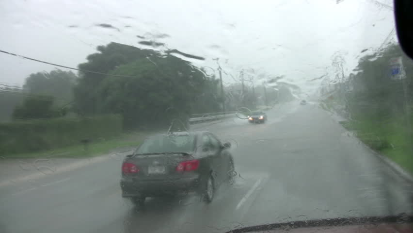 Video of flooded road in San Antonio Texas. Massive rains causing many accidents. Driving through deep water with windshield wipers working. Cars and trucks passing. Residential area.