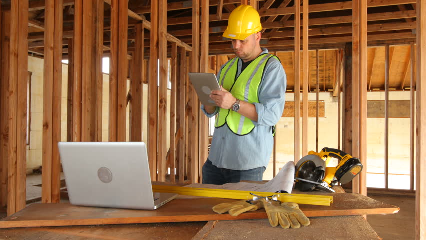 Construction worker using digital tablet on work site.  4K / Ultra HD