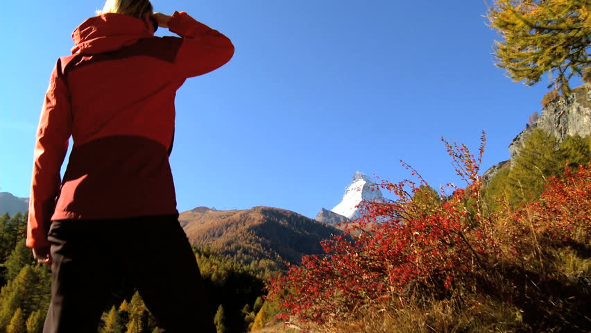 Fall in an alpine meadow, Zermatt, with female hiker & the Matterhorn, motion jib
