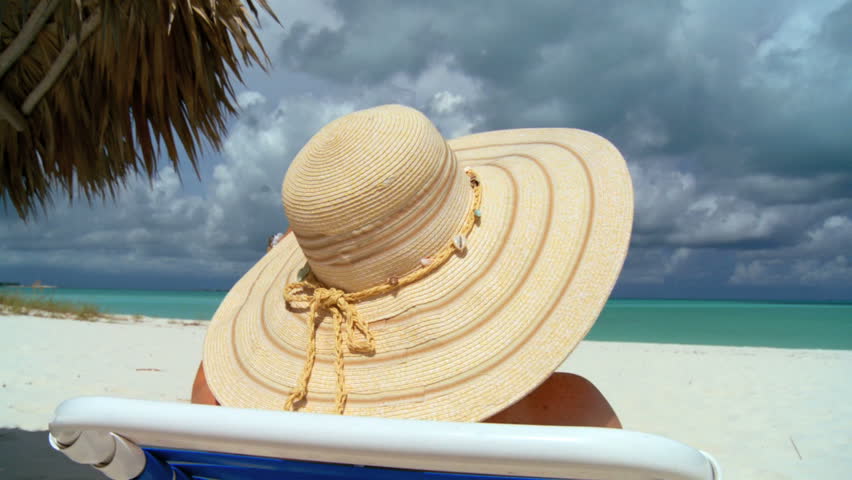 Elegant young female relaxing on white sandy beach looking at aquamarine waters 60 FPS