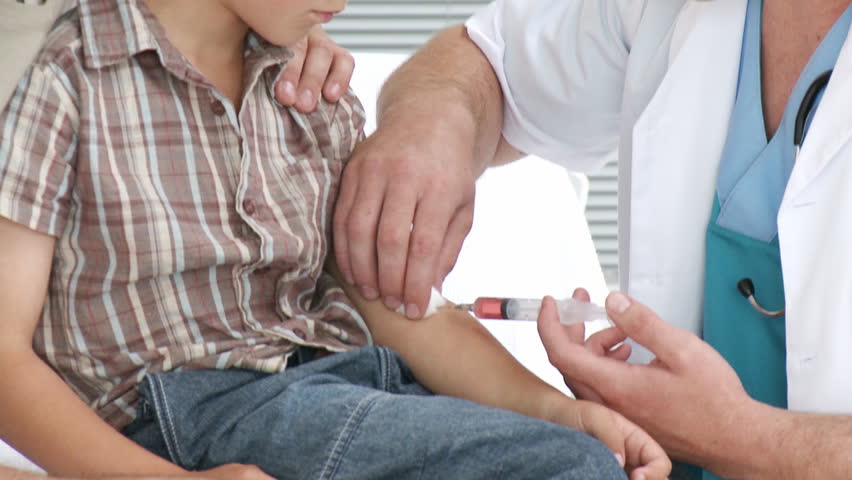 Doctor giving a little boy an injection