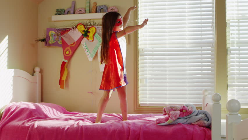 Young girl dressed as superheroes playing at home - 4K
