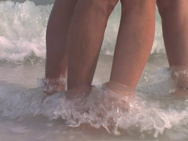 Sexy and sensual shot of exotic couple on the beach.  Moves from feet up to the kiss.