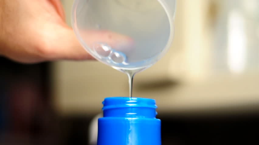 Pouring laundry detergent.  Shallow depth of field.