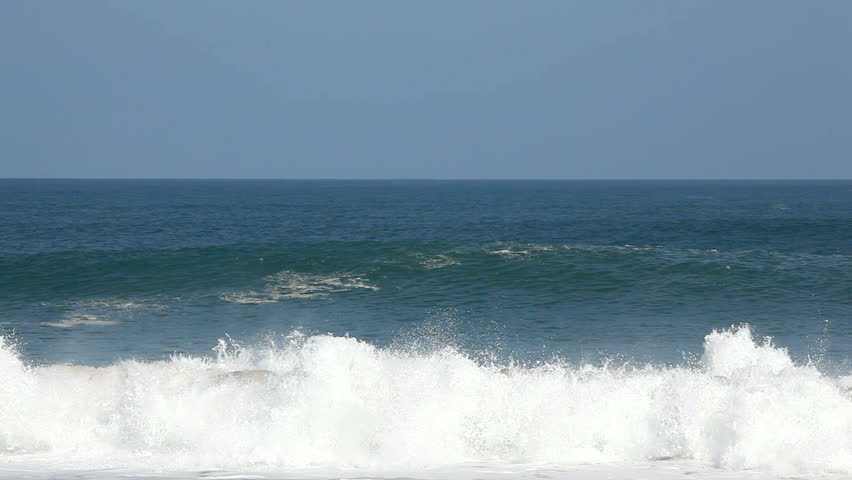 Rolling breakers off the north coast of Kauai on Lumahai beach break towards the beach and show rainbows in the spray