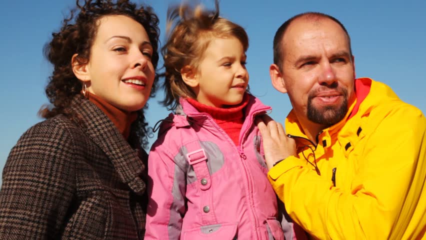 portrait of mum, daddy and daughter together against clear sky 