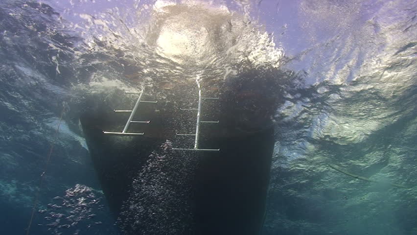 Back deck of dive boat showing the dive ladders in a rough sea.
