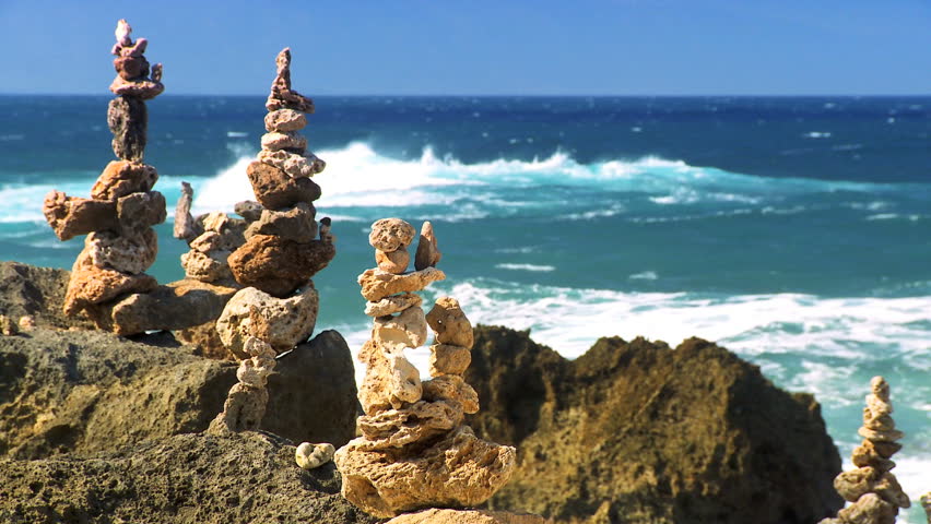 Natural rock stones balanced on shoreline with ocean backdrop