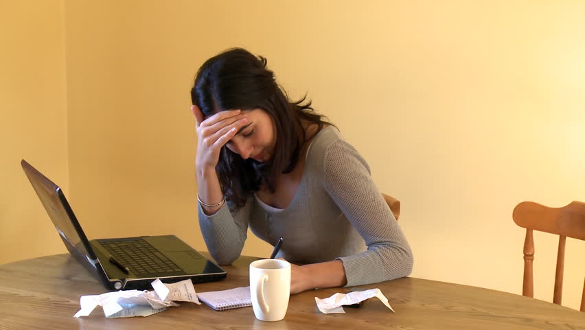 Weary woman doing her accounts at home 