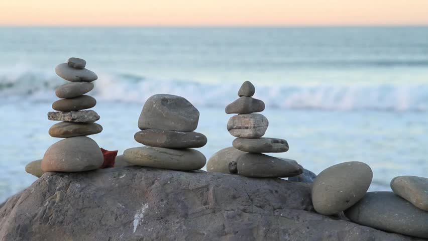 Rocks Balanced, Pastel Blue Ocean, Surfer Passes by in Background.