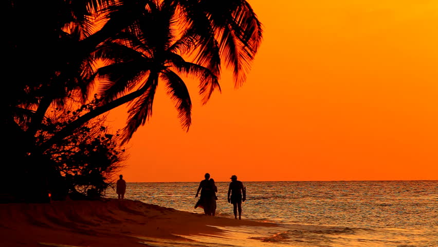 people at sunset on tropical beach 