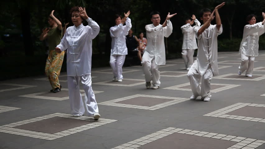 CHENGDU, CHINA - AUGUST 10: Chinese man and woman dressing white silk practice balancing Tai Chi in the People's Park daily - Chengdu, China in Sichuan Province, August 10, 2009