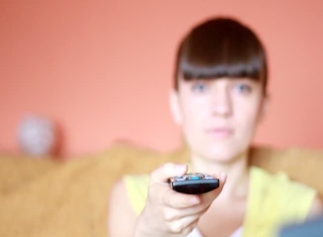 Dolly shot of Woman on a sofa with a tv remote control - NTSC