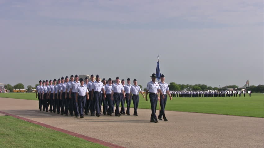 Video of USAF enlisted Basic Training graduates marching by parade field for ceremony. Blue uniform with Drill Sergeant leading. Lackland AFB San Antonio, Texas. 