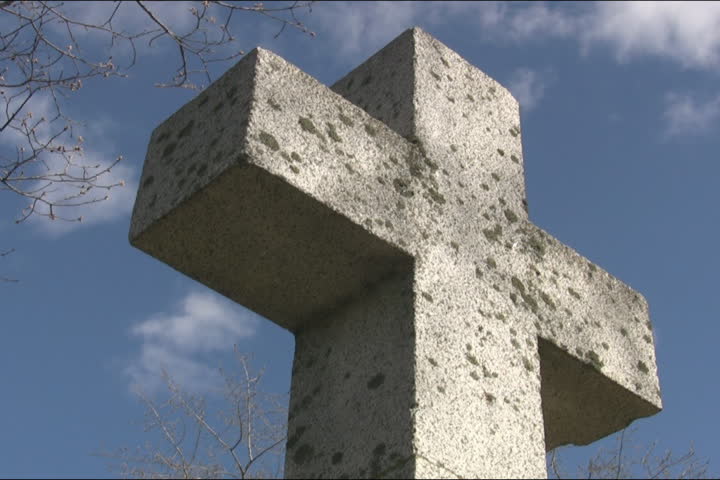 Cemetary cross. Light timelapse. Gravestone marker with light timelapse clouds moving overhead.  