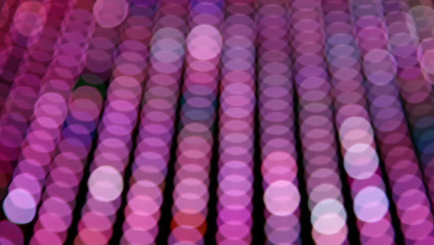 Blurred neon lights, predominantly pink, moving across frame