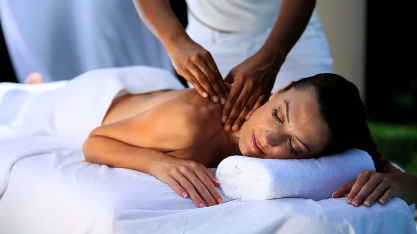 Sophisticated lady relaxing with massage treatment by masseur at a luxury health & beauty spa
