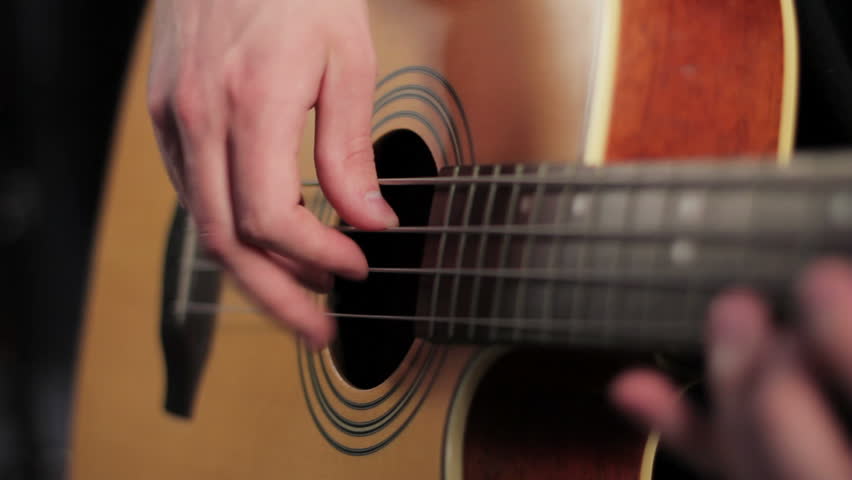 Man playing acoustic bass in studio, shallow depth of field
