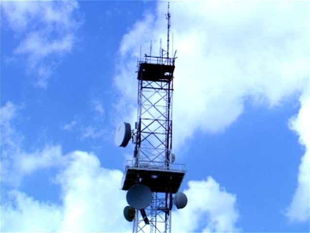 Telecommunication tower against blue sky with clouds. Time Lapse. 