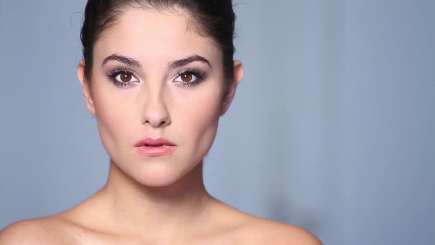 Beautiful young woman applaying cosmetics 