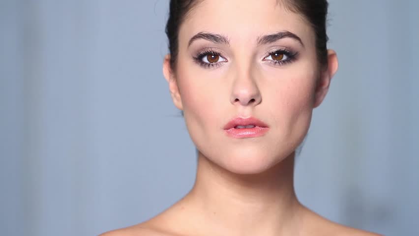 Beautiful young woman applaying cosmetics 