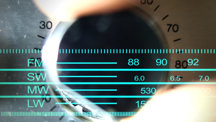 closeup of hand turning a volume control on an old hifi