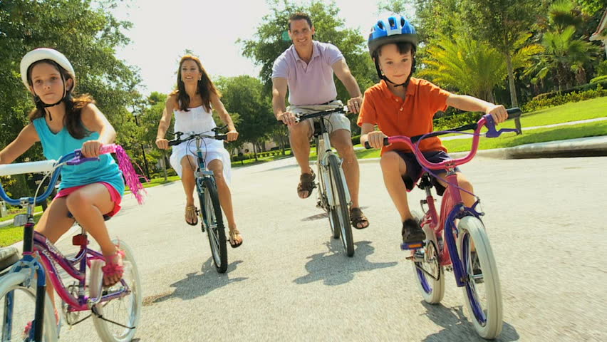 Attractive healthy caucasian family enjoying keeping fit together cycling outdoors 60FPS