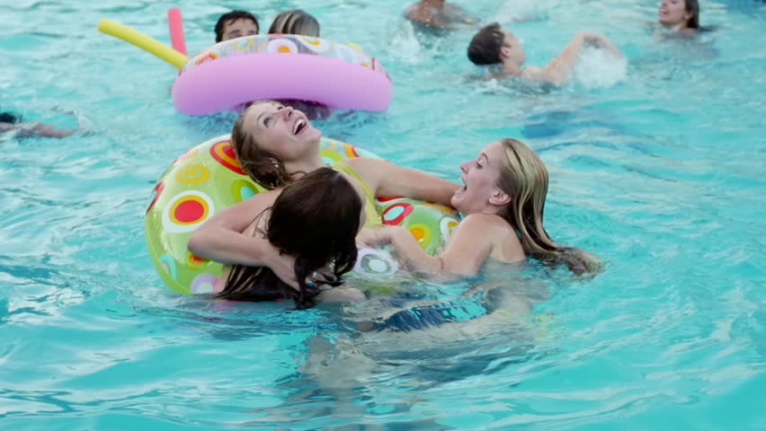 Teen Friends Have A Fun Chicken Fight At A Pool Par
