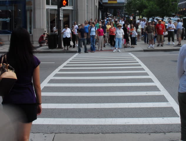 Crowds crossing urban street time lapse