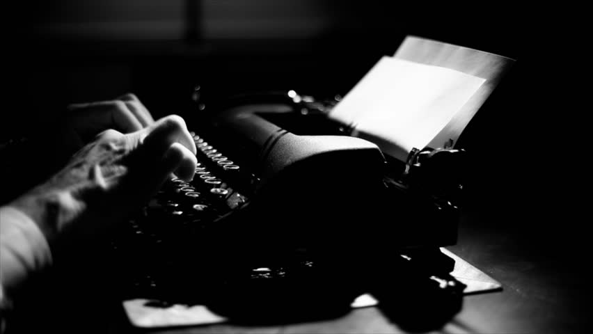 Light focuses on the hands of a man typing on a vintage 40's style manual typewriter. Film Noir Lighting and affect.