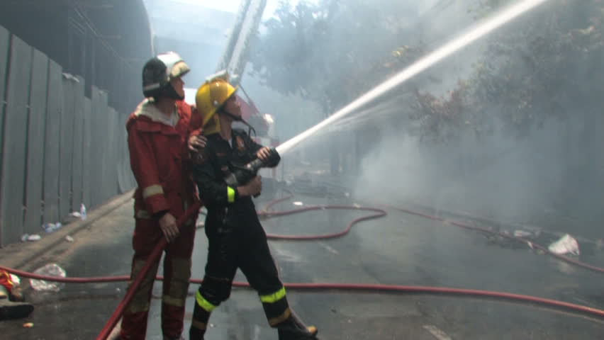BANGKOK, THAILAND - April 19, 2010: Firemen battle blazes across the city after protesters set more than 40 buildings on fire during a government crackdown 