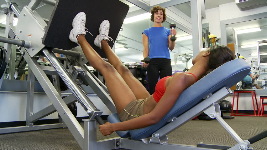 Two young women friends working out at gym