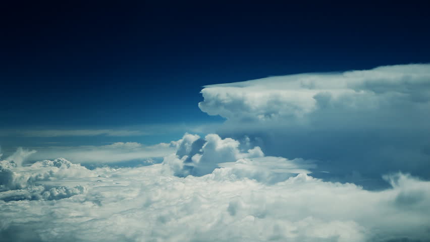 Abstract cloud shapes floating by. Natural movements of airplane causing shakiness of footage which is shot from plane window