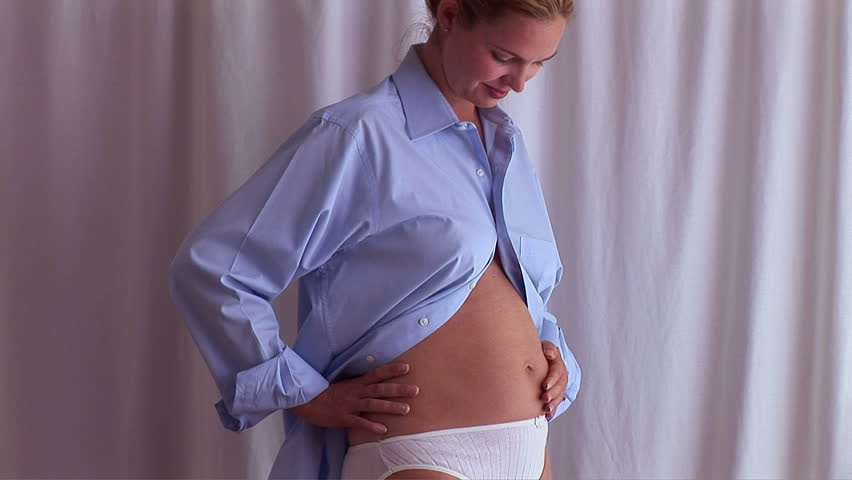 Pregnant woman posing in man's blue shirt