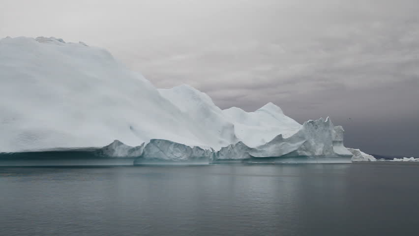 Sailing by an iceberg in the famous Ilulissat icefjord in Greenland. The icefjord is on UNESCO's World Heritage List.