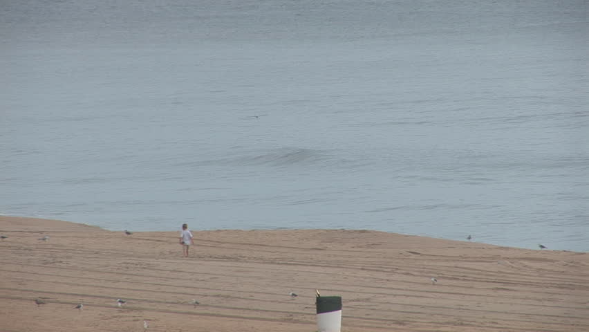 Little boy walking alone on beach