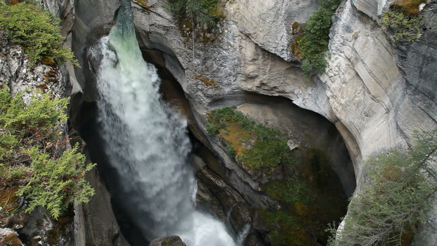 River waterfall gorge at Maligne Canyon, Banff National Park, Alberta, Canada. Rushing water pours through narrow gorge created by the forces of water. Popular vacation and naturalist destination.