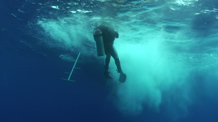 Low angle view of a scuba diver entering the water from a boat