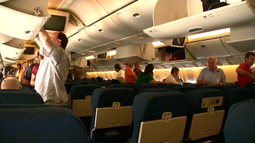 HD people boarding a Boeing 777 and locating their seats- two clips