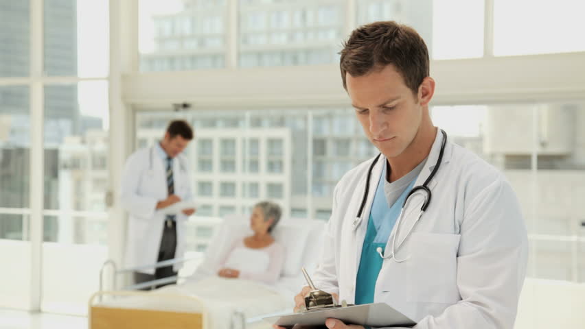 Handsome Young Doctor Smiling in a Hospital Room