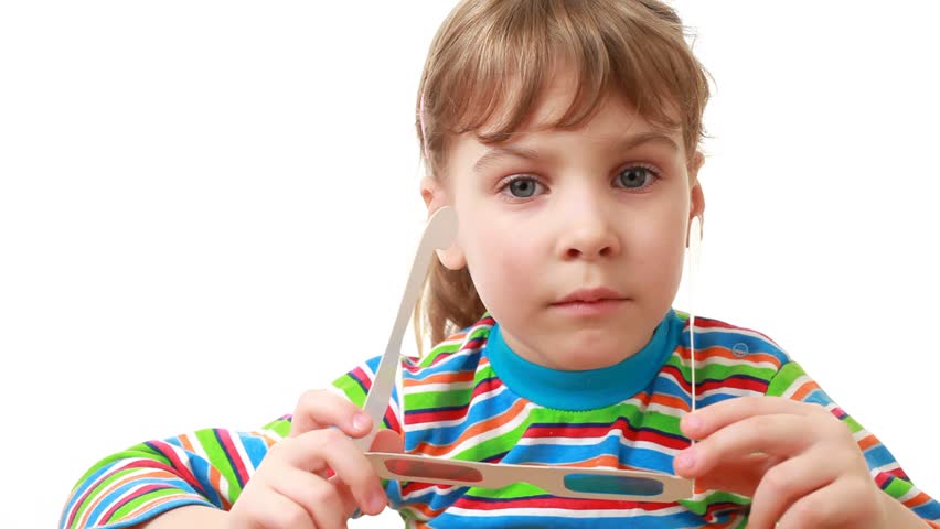 Little girl in a striped shirt with long sleeves wears anaglyph (3d) glasses experiences rapture and exhilaration