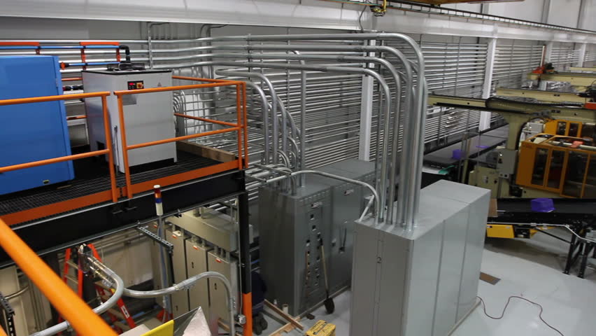 A wide shot panning across a large assembly factory. 