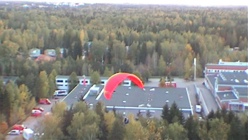 Successful paraglider landing, tripod, 16x9